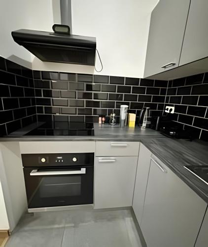 a kitchen with white cabinets and a black oven at Ideal Room Near Gare du Midi in Brussels