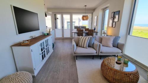 a living room with a tv and a couch and a table at Ferienwohnung "Surfside" in Schönberg-Kalifornien in Kalifornien