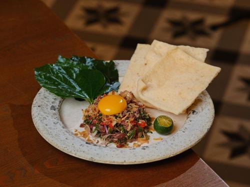 a plate of food with an egg and chips on a table at Sofitel Saigon Plaza in Ho Chi Minh City