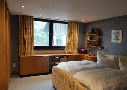 a bedroom with a bed and a desk and a window at Ferienhaus mit Schwimmhalle in Burgthann