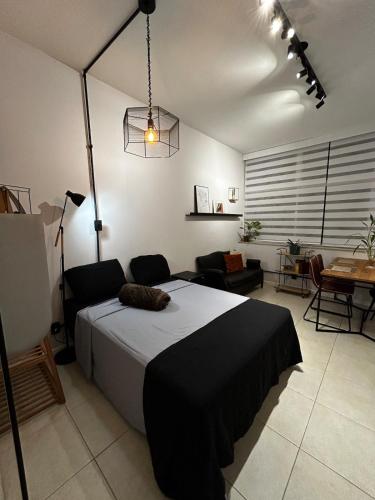 a bedroom with a bed and a living room with a table at Loft com área de trabalho isolado - Centro do Rio de Janeiro in Rio de Janeiro