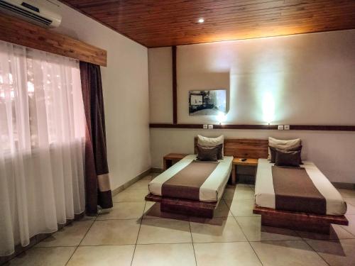 a room with two beds and a window in it at Moringa Hotel in Toliara