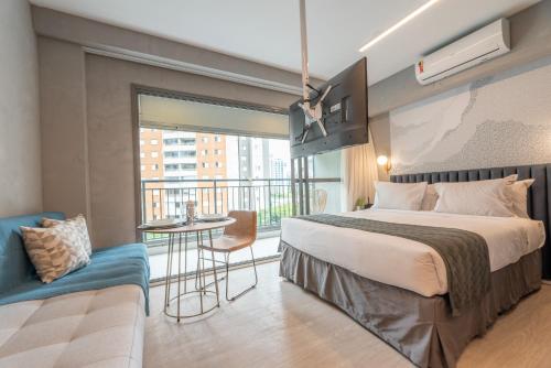 a hotel room with a bed and a balcony at Charlie Vitrali Moema in Sao Paulo