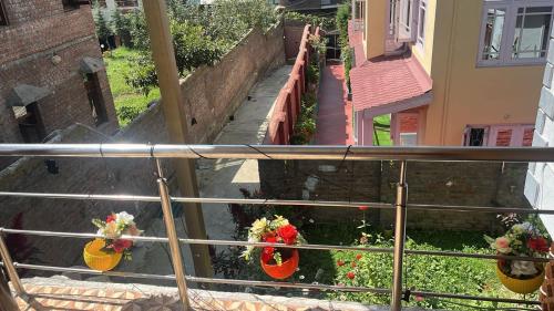 a view of a balcony with flowers in vases at Al Mubeen home stay in Nishāt