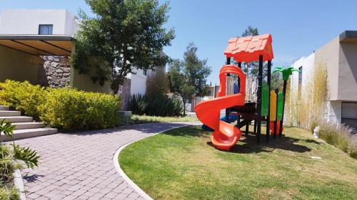 a playground with a red slide in a yard at Perfect for Vacationing 