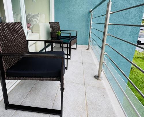 a balcony with chairs and a table and a couch at Vive Luxe Condo w Pool & 247 Security near Airport in Dabadie