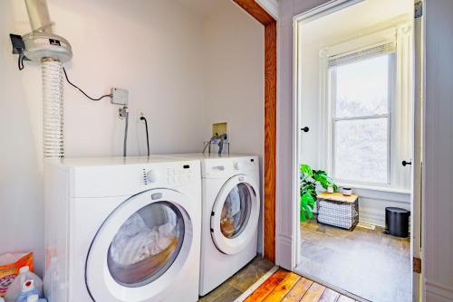a laundry room with a washing machine and a window at Short North Convention King Bed Free Parking! in Columbus