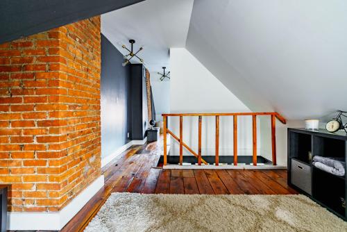 a room with a brick wall and a staircase at Short North Convention King Bed Free Parking! in Columbus