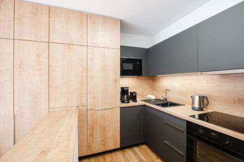 a kitchen with wooden cabinets and a sink at Landal Marina Lipno in Lipno nad Vltavou