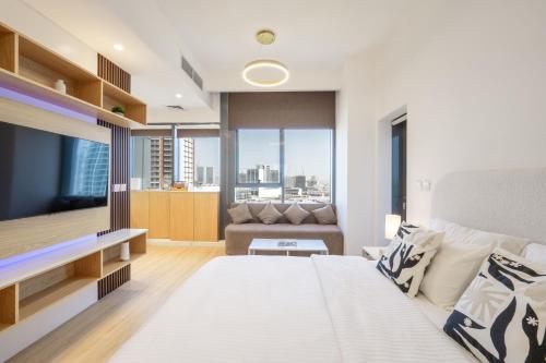 a bedroom with a large bed and a couch at Luxury Studio JVC Open View in Dubai