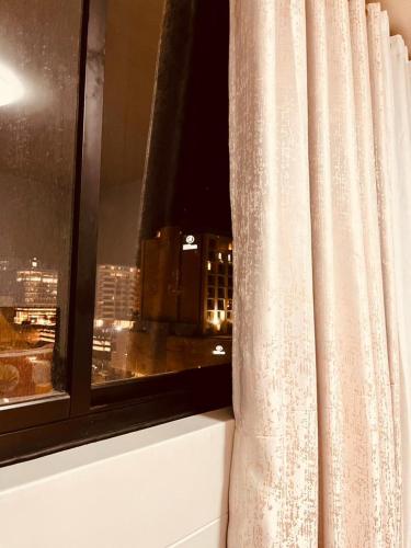 a curtain in a window with a view of a city at Hora Quente in Windhoek