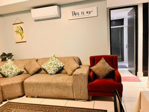 a living room with a couch and a red chair at Hora Quente in Windhoek
