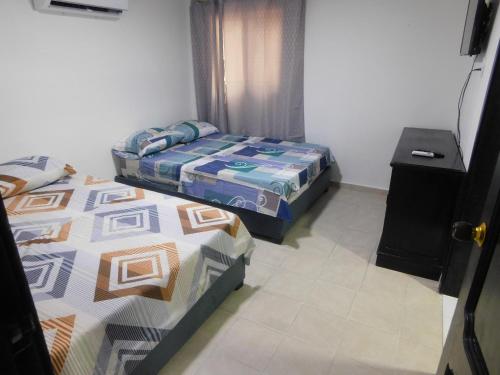 a bedroom with two beds and a night stand at El Velero Apartamentos By DANP in Santa Marta