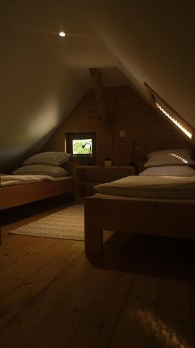 a attic room with two beds and a window at Lake house Amur in Kočevje