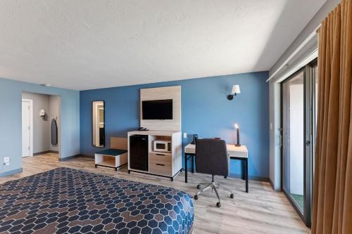 a bedroom with blue walls and a desk and a bed at Pilgrim Sands on Long Beach in Plymouth