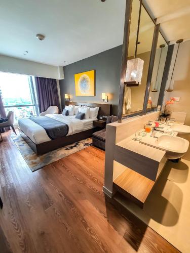 a bedroom with a bed and a sink and a mirror at Novotel Hotel Residence Manila at Acqua in Manila
