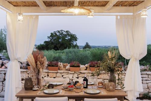 a table set up for a dinner party under a pavilion at Trulli Arborea in Alberobello