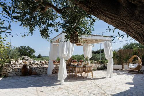 a table and chairs under a white canopy at Trulli Arborea in Alberobello