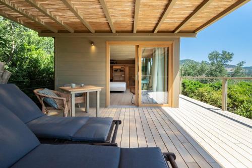 a deck with a couch and a table on a house at Boutique Hotel Poggio ai Santi - Adults Only in San Vincenzo