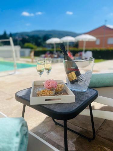 a tray of food and wine glasses on a table next to a pool at The Florence Hills Resort & Wellness in Pelago