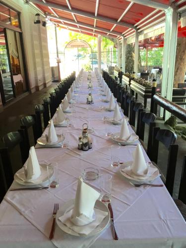 a long table with plates and napkins on it at Hotel Vila Vrbas in Banja Luka
