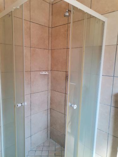 a shower with a glass door in a bathroom at NEMARA Self Catering Lodge in Polokwane