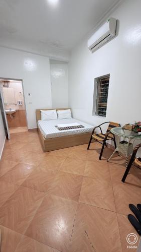 a bedroom with a bed and a table in a room at Nha Nghi Phu Quy in Phú Nặng