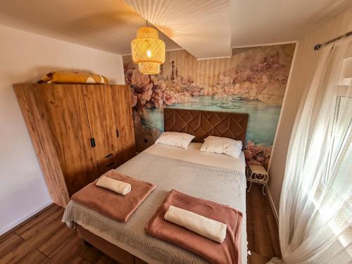 a bedroom with a large bed with a painting on the wall at Goldy in Neum
