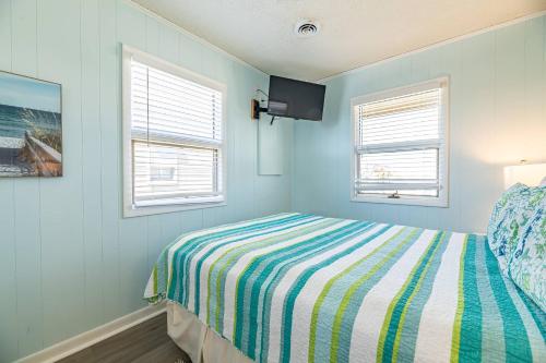 a blue bedroom with a bed and two windows at Sea II Views in Whalebone