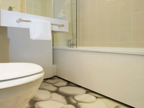 a bathroom with a white toilet and a shower at ibis Styles Bordeaux Aéroport in Mérignac
