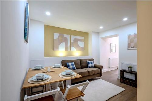 a living room with a table and a couch at Modern Comforts – 4 Bedroom Home for Work & Play in Swansea