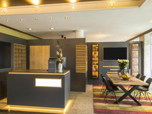 a dining room with a table and chairs at Mercure Hotel Bad Oeynhausen City in Bad Oeynhausen