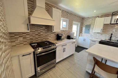a kitchen with white cabinets and a stove at Oceanfront Villa with Pool, Jacuzzi and Kayaks on Anguilla Island in Island Harbour