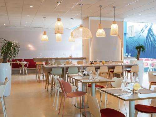 a restaurant with tables and chairs and lights at ibis Styles Toulon Centre Port in Toulon