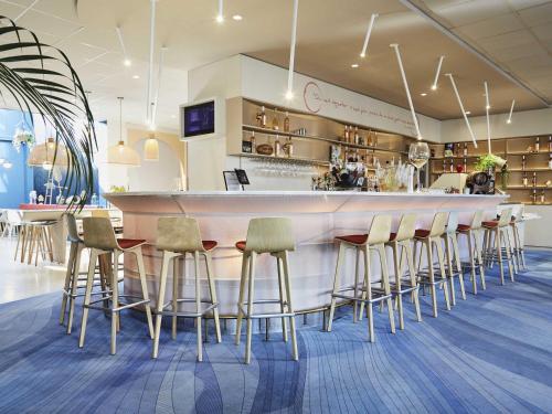 a bar with chairs and a counter in a restaurant at ibis Styles Toulon Centre Port in Toulon