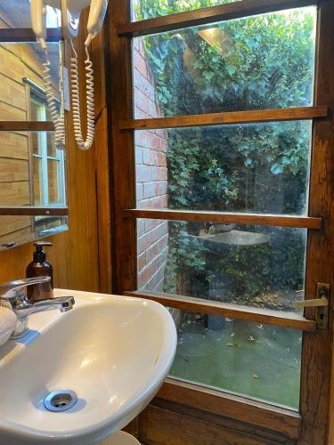 a bathroom with a sink and a window at Hain Casa Hotel in Punta Arenas