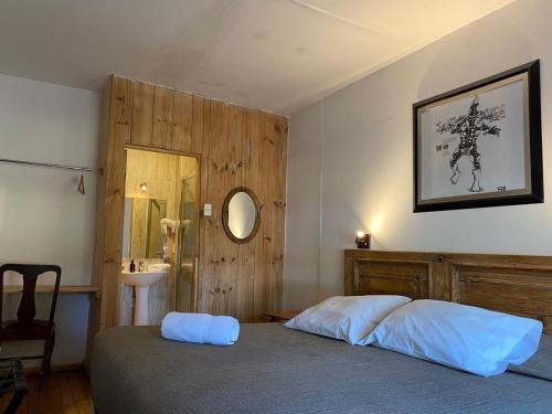 a bedroom with a bed and a mirror and a sink at Hain Casa Hotel in Punta Arenas