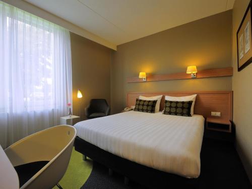 a hotel room with a bed and a window at Mercure Hotel Zwolle in Zwolle