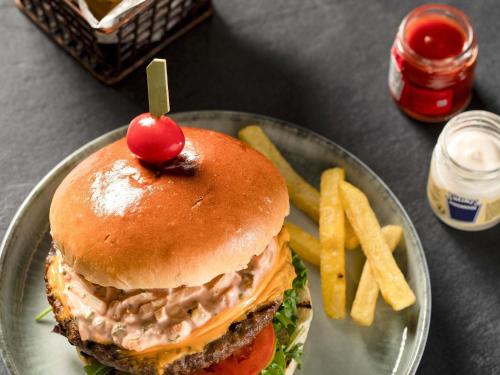 a plate of food with a sandwich and french fries at Mercure Hotel Zwolle in Zwolle