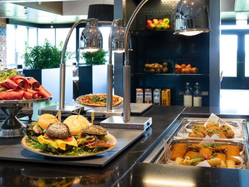 a buffet with several plates of food on a counter at Mercure Hotel Zwolle in Zwolle