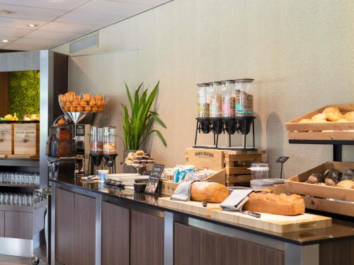 a bakery with a counter with bread and other foods at Mercure Hotel Zwolle in Zwolle