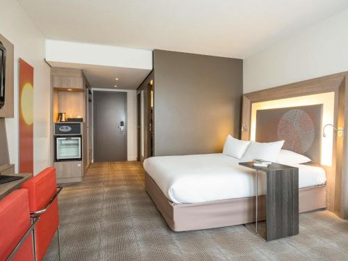 a hotel room with a bed and a kitchen at Novotel Brussels City Centre in Brussels