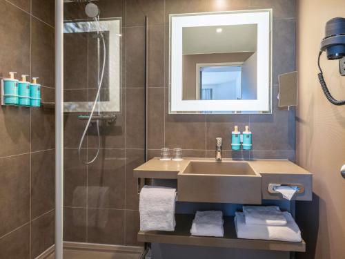 a bathroom with a sink and a shower at Novotel Brussels City Centre in Brussels