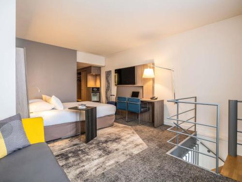 a hotel room with a bed and a kitchen at Novotel Brussels City Centre in Brussels