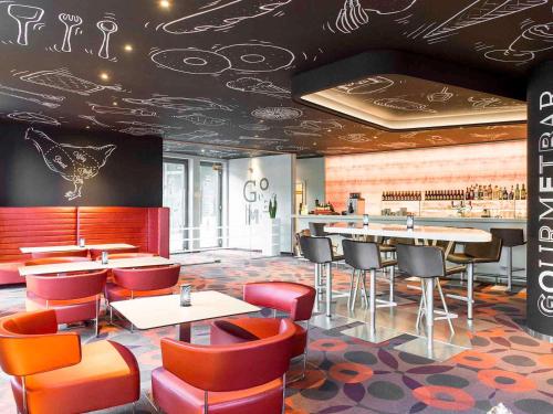 a restaurant with tables and chairs and a bar at Novotel Brussels City Centre in Brussels