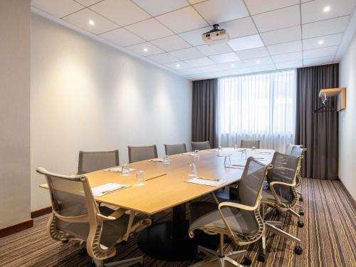 a conference room with a large table and chairs at Novotel Brussels City Centre in Brussels