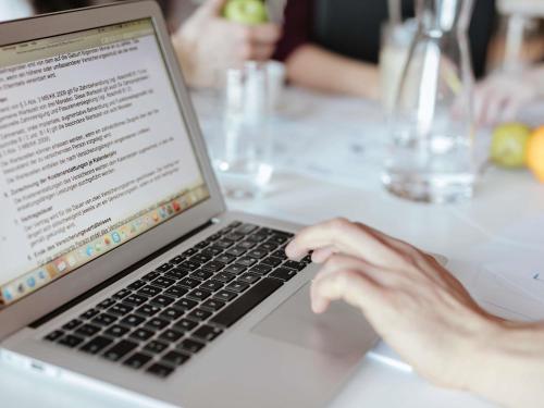 a person typing on a laptop computer on a table at Hotel ibis Lisboa Saldanha in Lisbon