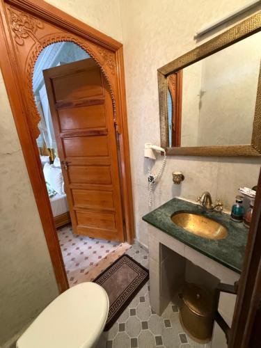 une salle de bain avec un lavabo, des toilettes et un miroir dans l'établissement Riad Jenan Adam, à Marrakech
