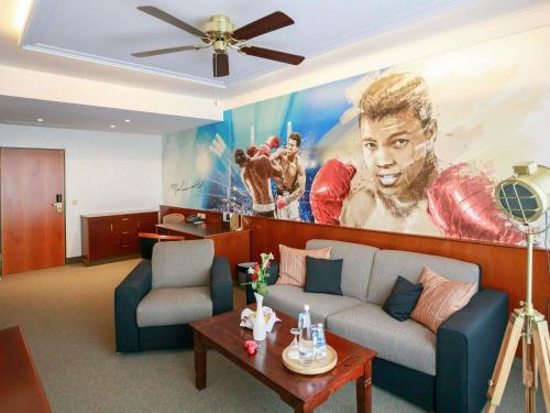 a living room with a large painting of a player at Mercure Hotel Riesa Dresden Elbland in Riesa