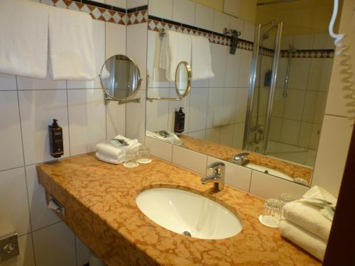 a bathroom with a sink and a mirror at Mercure Hotel Riesa Dresden Elbland in Riesa